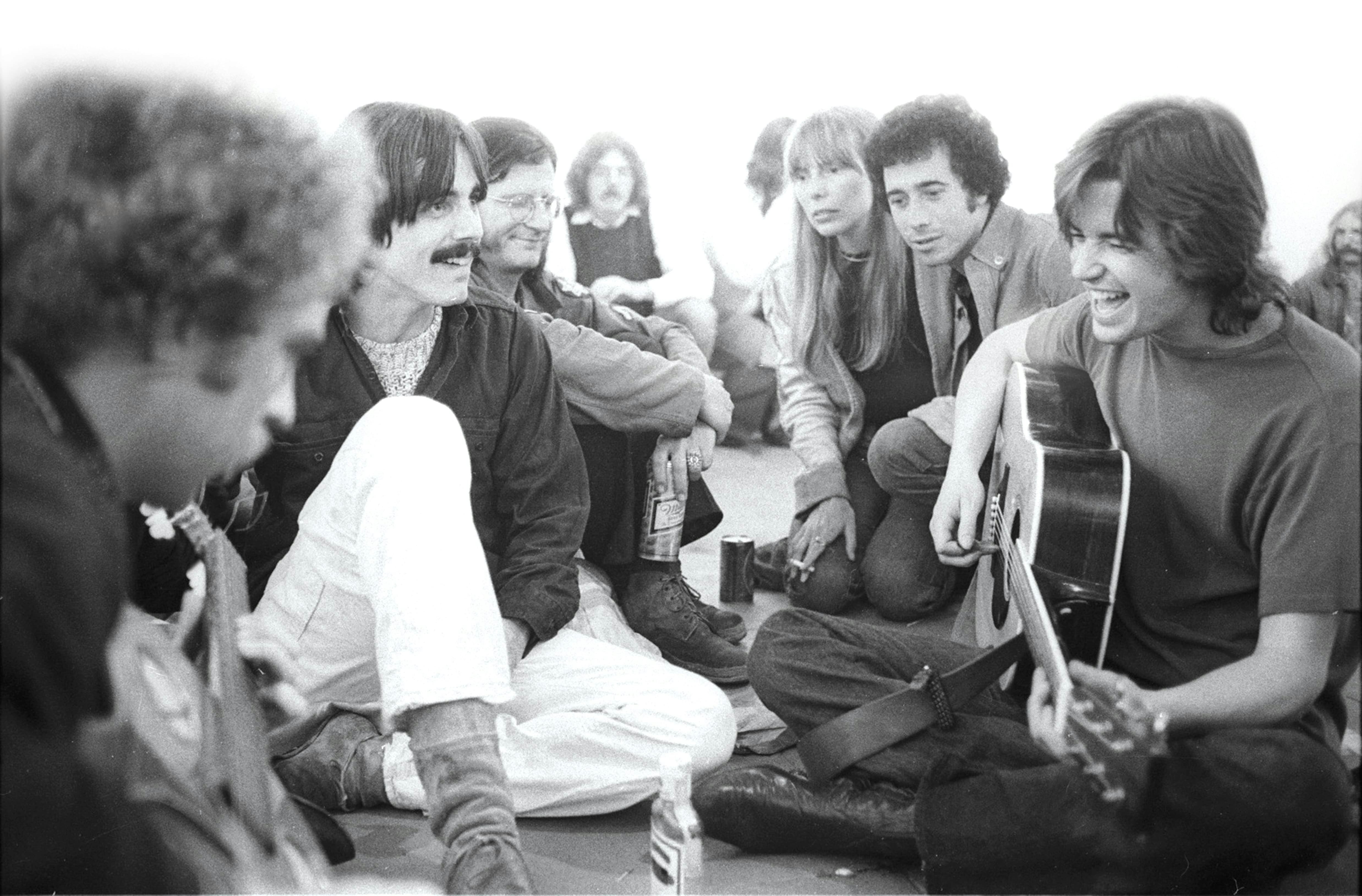 (left to right) Bernie Leadon of the Eagles, Jackson Browne, friend, Joni Mitchell, David Geffen, and Ned Doheny in Venice, California, 1972. Photo by Henry Diltz.